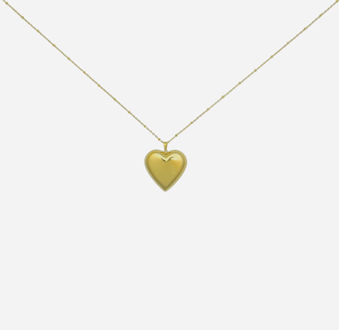 Gold heart pendant necklace on chain isolated on white background