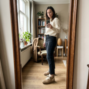 Person wearing beige suede sneakers with shearling lining indoor setting