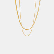 Gold-colored layered necklace against white background straight view