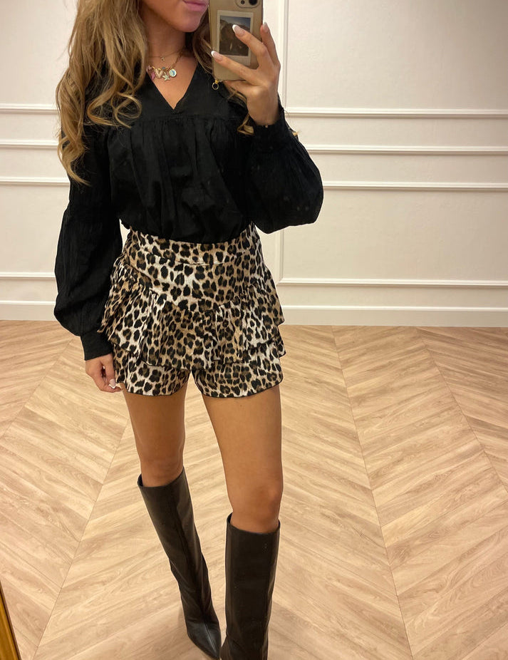 Leopard print mini skirt with black blouse and knee-high boots side view
