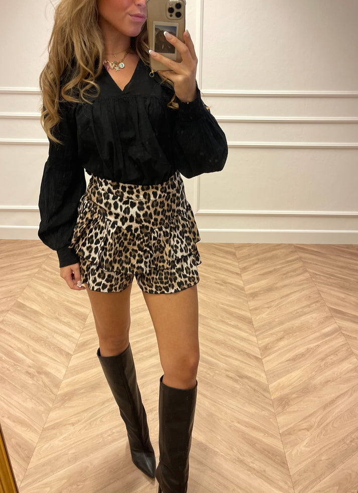 Leopard print mini skirt with black blouse and knee-high boots side view