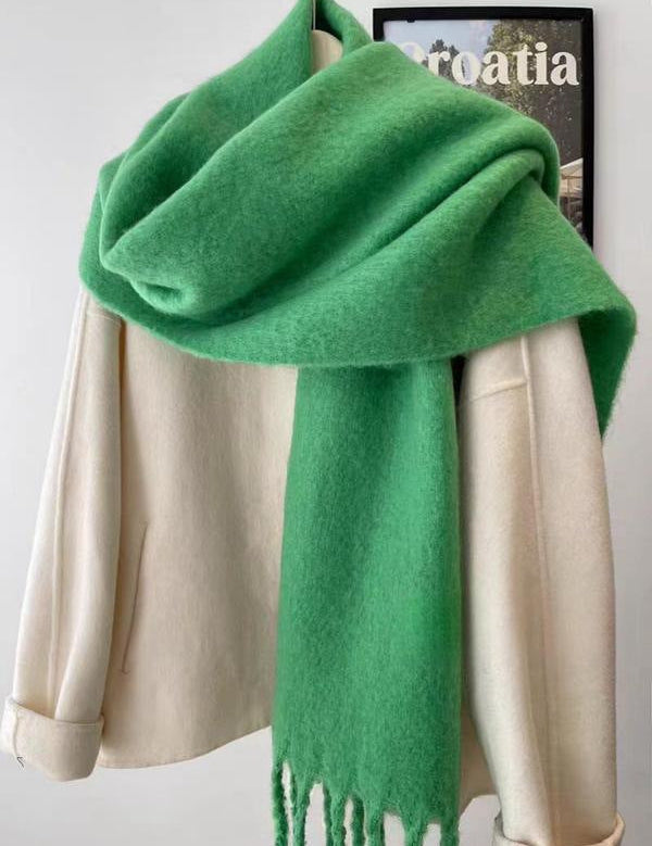 Green scarf with fringe draped over mannequin front view