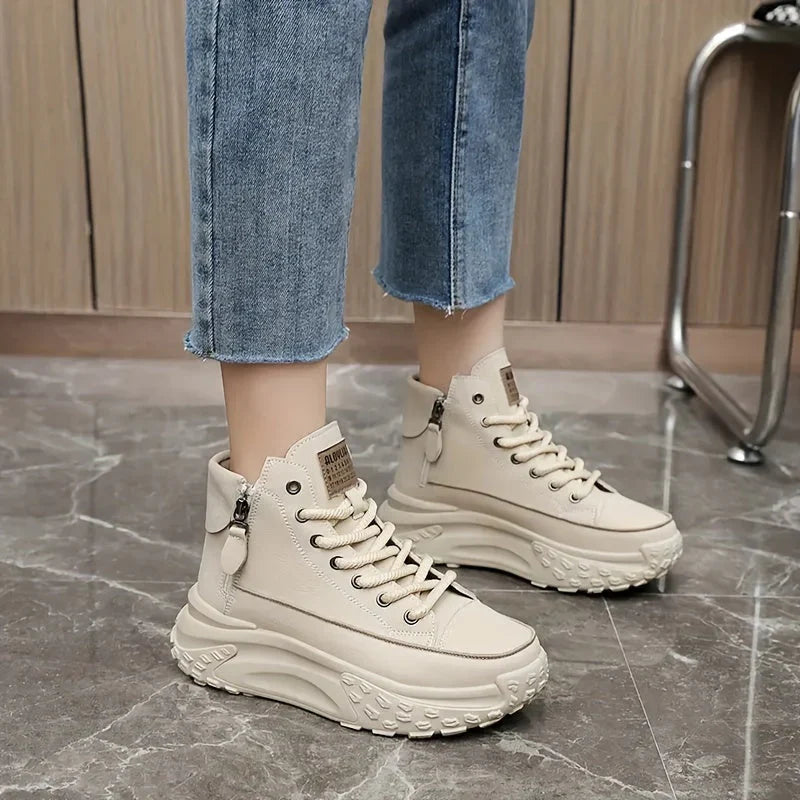 White high-top sneakers with platform sole worn with jeans close-up