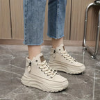 White high-top sneakers with platform sole worn with jeans close-up