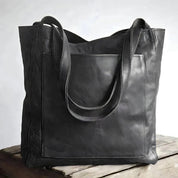 Black leather tote bag with exterior pocket front view