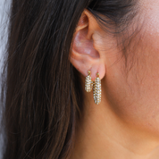 Gold hoop earrings with pave crystals worn on ear