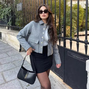 Model wearing gray jacket with gold buttons, front view