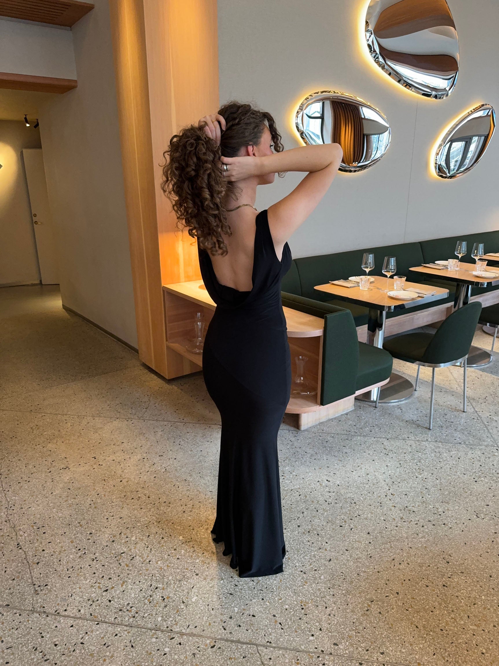 Evening dress black back view with hand on hair