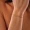 Gold armband with knot charm on wrist front view