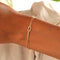 Gold armband with knot charm on wrist front view