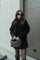 Violet gebreide set met zwart trui en rok, model met tas, front view
