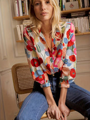 Blouse with vibrant floral pattern, seated pose
